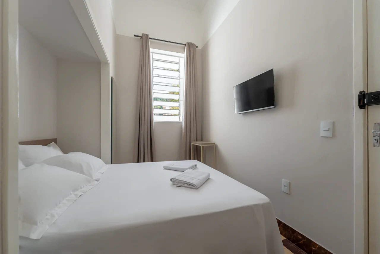 Quarto com televisão e vista para a janela