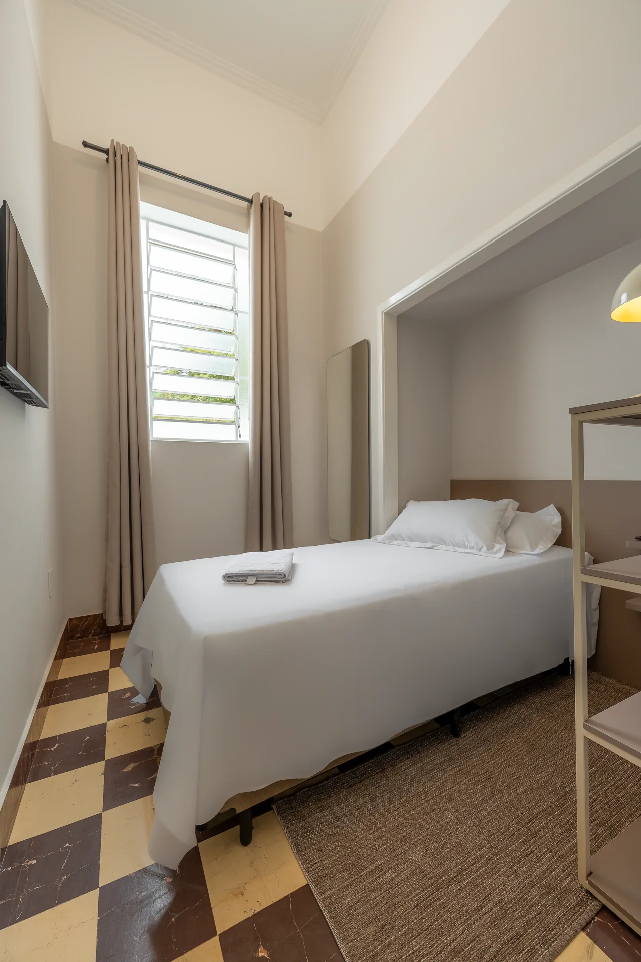 Quarto com pé-direito alto e piso xadrez